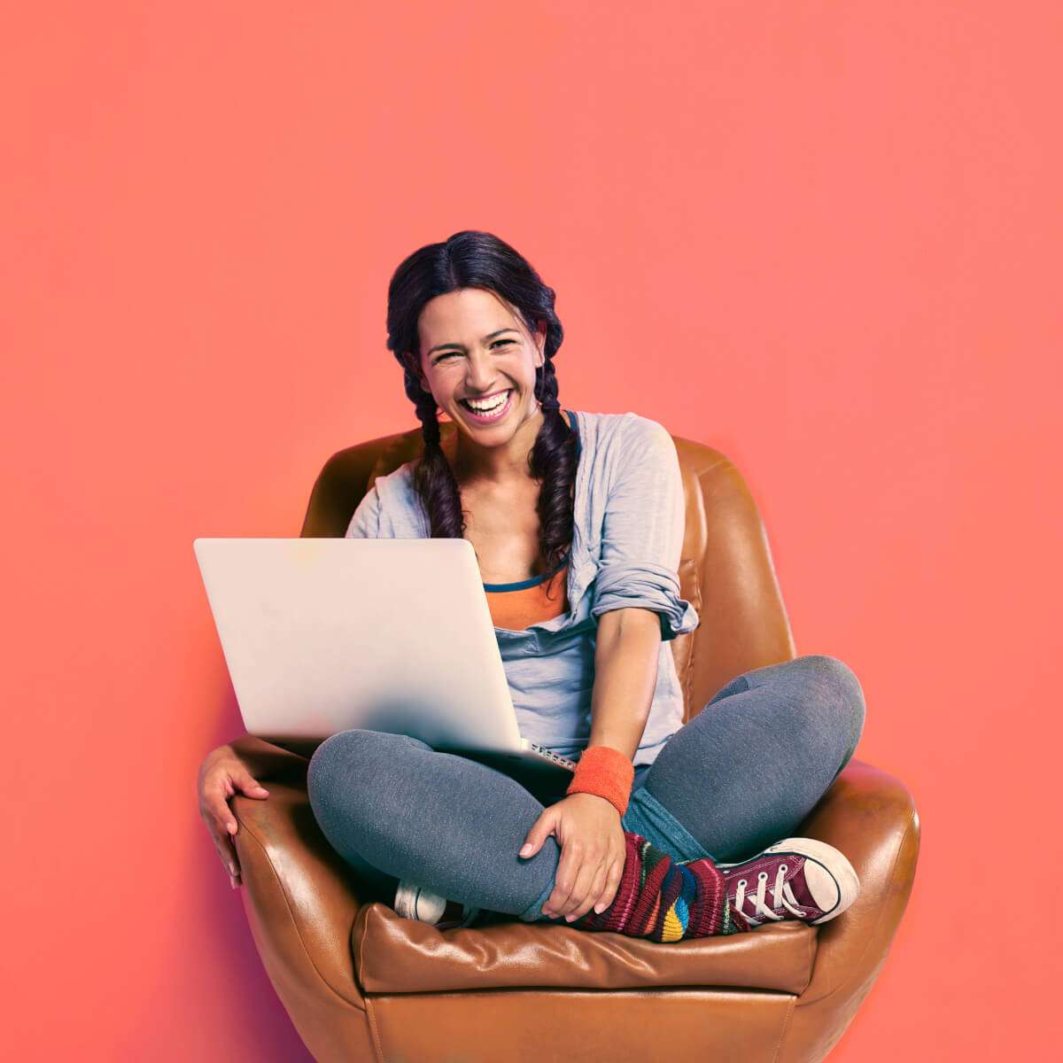 woman laughing with a laptop in her lap