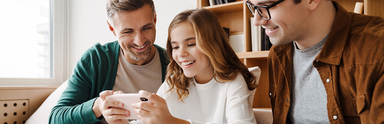 Dads and daughter using mobile device together