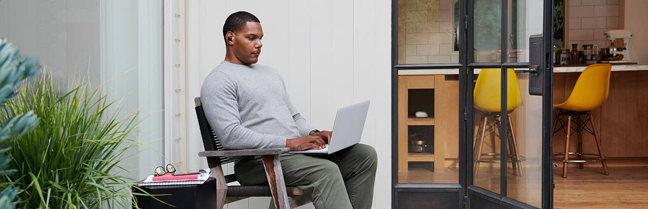 a guy sitting with a laptop on his lap