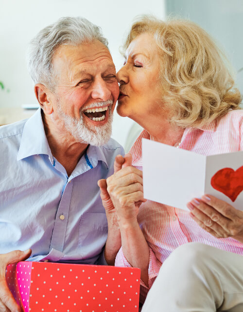 Older couple kissing and exchanging gifts for Valentines Day